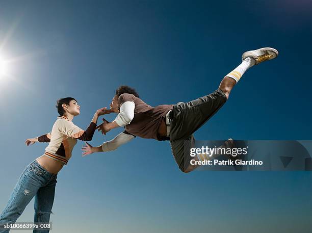young couple dancing, low angle view - danseur photos et images de collection