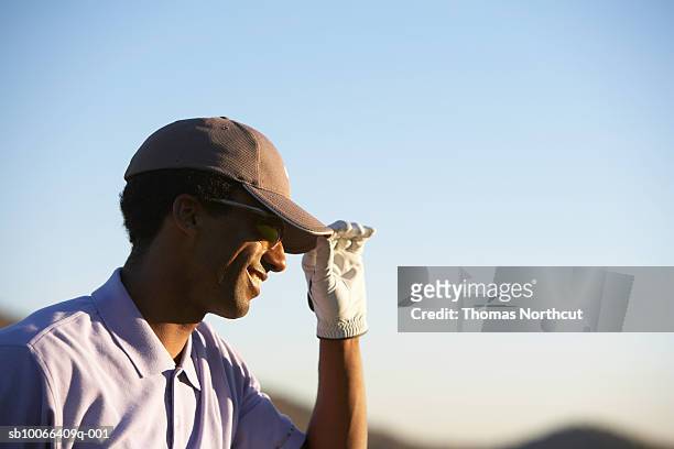 male golfer holding cap on golf course - golfers stock pictures, royalty-free photos & images