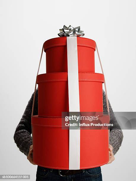 young woman carrying stack of red gift boxes - pile of gifts stock pictures, royalty-free photos & images