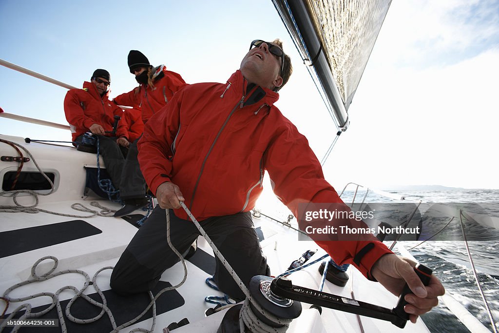 Crew sailing racing yacht