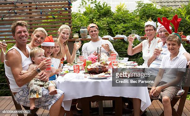 family with children (1-12 years) raising glasses, wearing christmas hats at outdoor table - 12 13 years old girls imagens e fotografias de stock