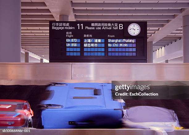 china, hong kong chek lap kok international airport (lantau island), suitcases on conveyor belt at bagage reclaim area - baggage claim stock pictures, royalty-free photos & images