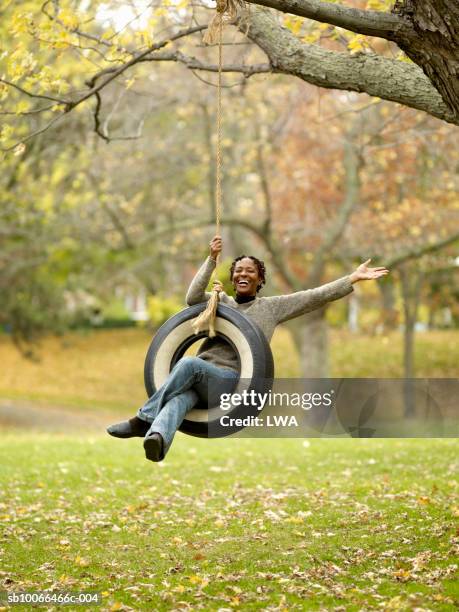 mature woman on tyre swing, smiling - swing bildbanksfoton och bilder