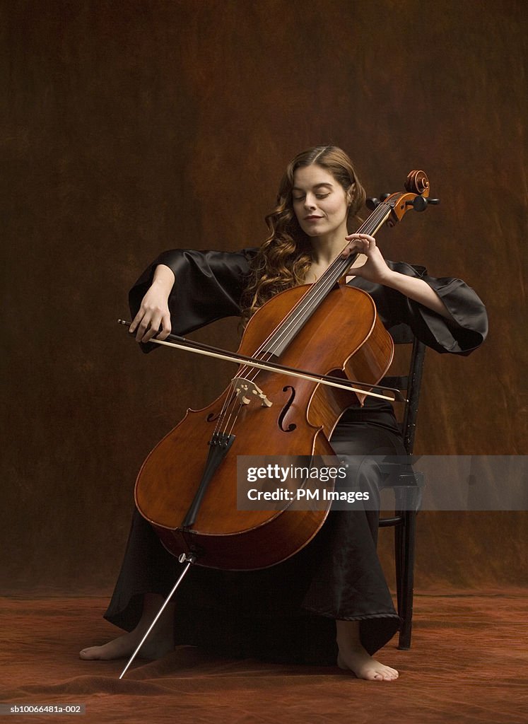 Young woman sitting on playing cello