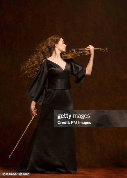 young woman playing violin, eyes closed, side view - violin 個照片及圖片檔