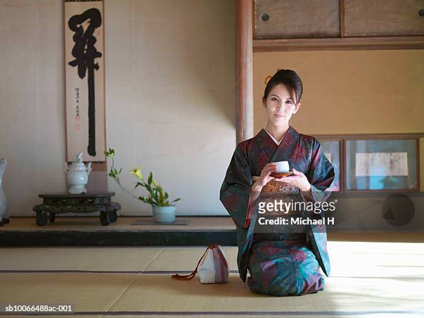 japan, kyoto, enko temple, woman in kimona with tea cup kneeling in temple, portrait - kakemono japonais photos et images de collection