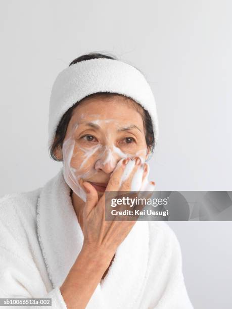 senior woman washing face, close-up - foaming face wash stock pictures, royalty-free photos & images