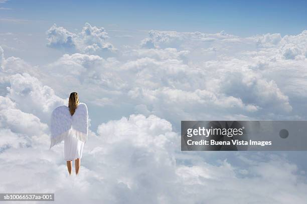 woman with angel's wings standing on clouds, rear view (digital composite) - heaven angels stock pictures, royalty-free photos & images