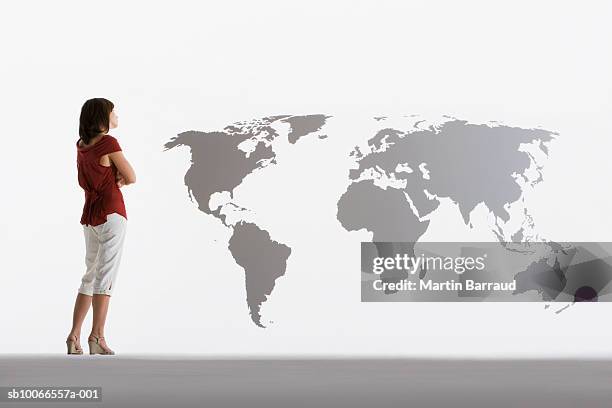 woman looking at map of world on clear acrylic sheet - woman full body behind stock pictures, royalty-free photos & images