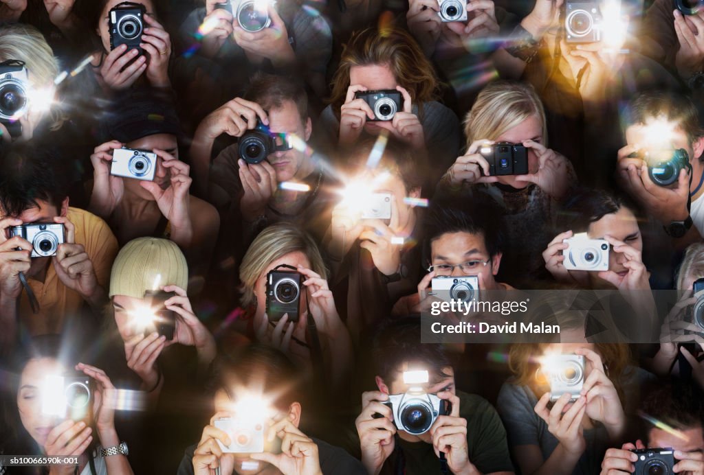 Crowd of people taking photos with small cameras, high angle view