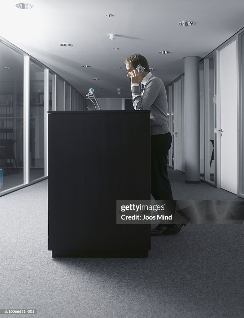 Businessman using mobile phone and webcam in office