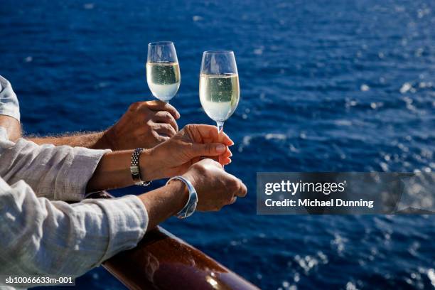 hands holding champagne glass on cruise ship - cruise vacation stock-fotos und bilder