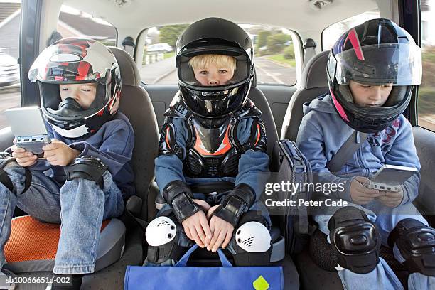 boys (6-11) sitting in car wearing helmets - kid car safety stock pictures, royalty-free photos & images