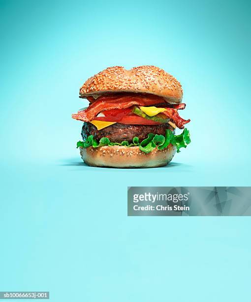 burger on blue background - bacon cheeseburger stock-fotos und bilder