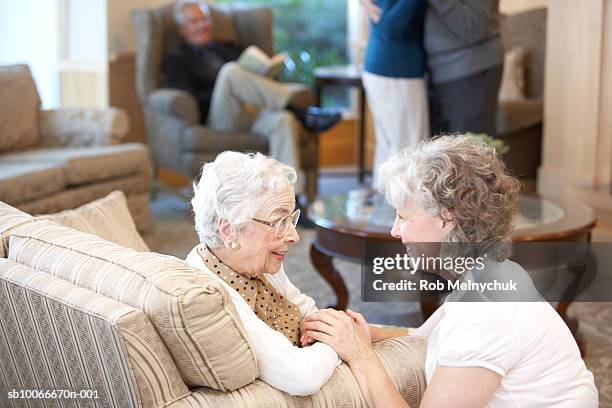 nurse comforting senior woman in retirement home - mother daughter senior stock-fotos und bilder