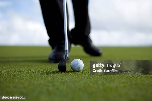 person putting golf ball, low section (differential focus) - golf putter stock pictures, royalty-free photos & images