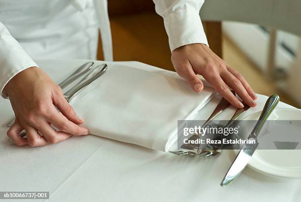 waitress adjusting table settings in restaurant, mid section - porslin bildbanksfoton och bilder