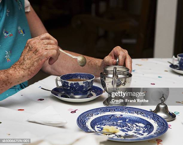 senior woman stirring afternoon tea at table, mid section - santa cruz de la sierra bolivia stockfoto's en -beelden