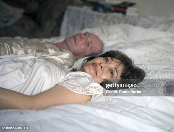 mature couple lying on bed - sucre stock pictures, royalty-free photos & images