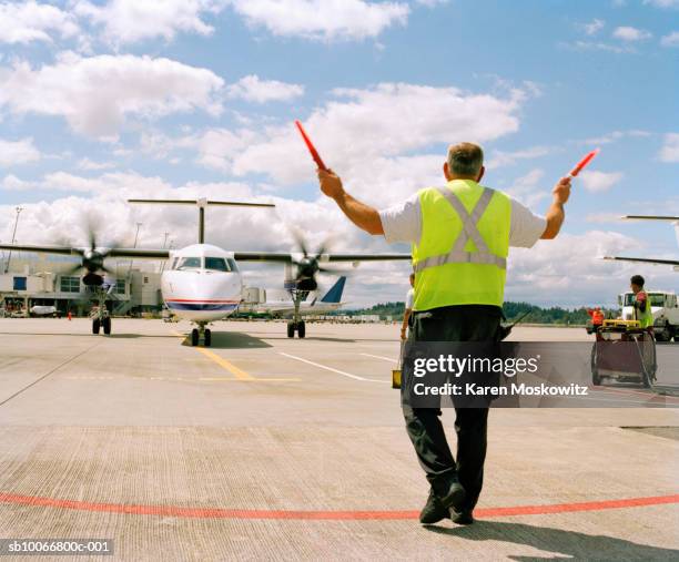 airport ground crew directing aircraft, rear view - airport ground crew stock pictures, royalty-free photos & images