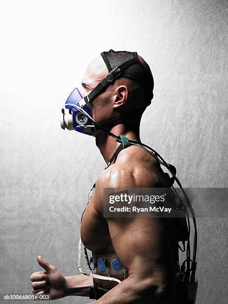 man running with oxygen mask and ekg, close-up, side view - oxygen mask stock-fotos und bilder