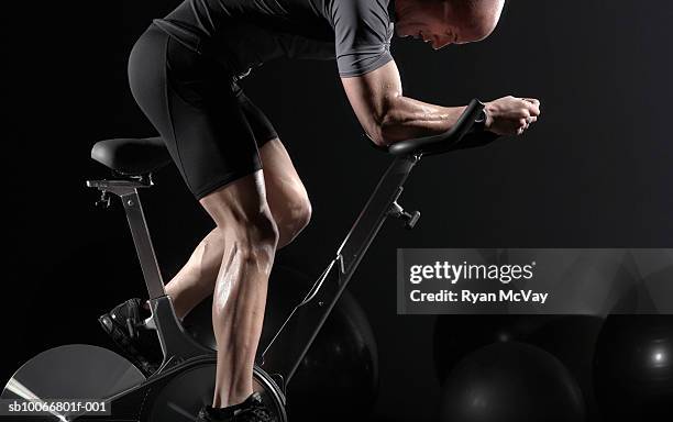 man cycling on exercise bike, side view - heimtrainer stock-fotos und bilder