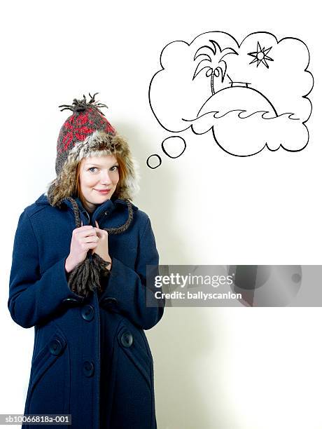 young woman wearing winter coat with tropical island in thought bubble - tagträumen stock-grafiken, -clipart, -cartoons und -symbole