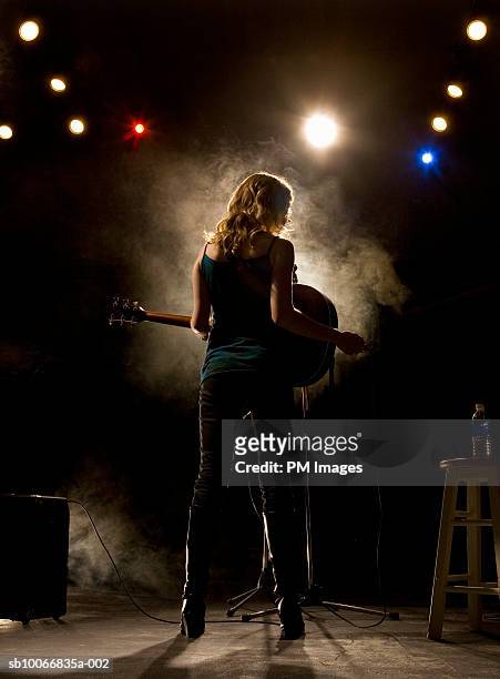 woman playing guitar on stage, rear view - rock musician stock pictures, royalty-free photos & images