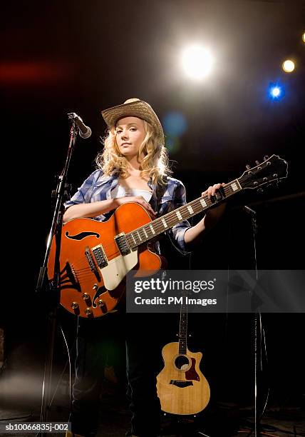 woman with guitar on stage, portrait - country and western music stock-fotos und bilder