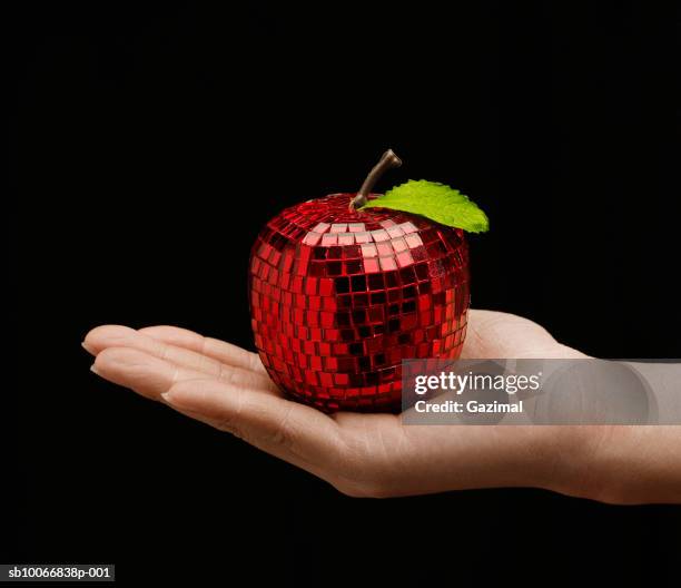 woman holding mirrored apple in palm, close-up - fake food stock pictures, royalty-free photos & images