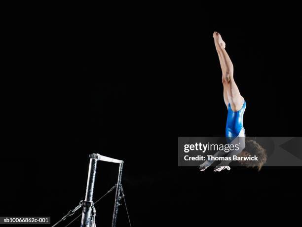 gymnast (9-10) dismounting uneven bars - gymnastics bar stock pictures, royalty-free photos & images