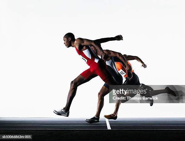 three male runners crossing finish line - avvenimento sportivo foto e immagini stock