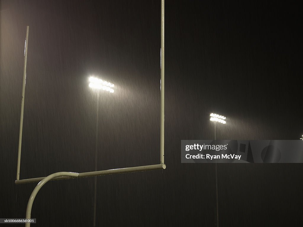 Floodlight illuminated at night, goal in foreground