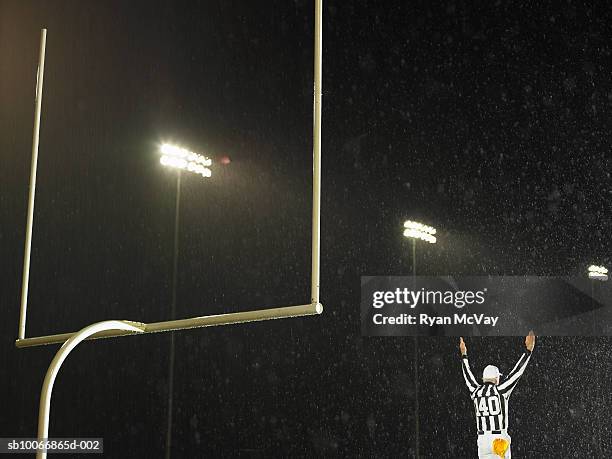 american football referee giving touchdown signal, rear view - touch down foto e immagini stock