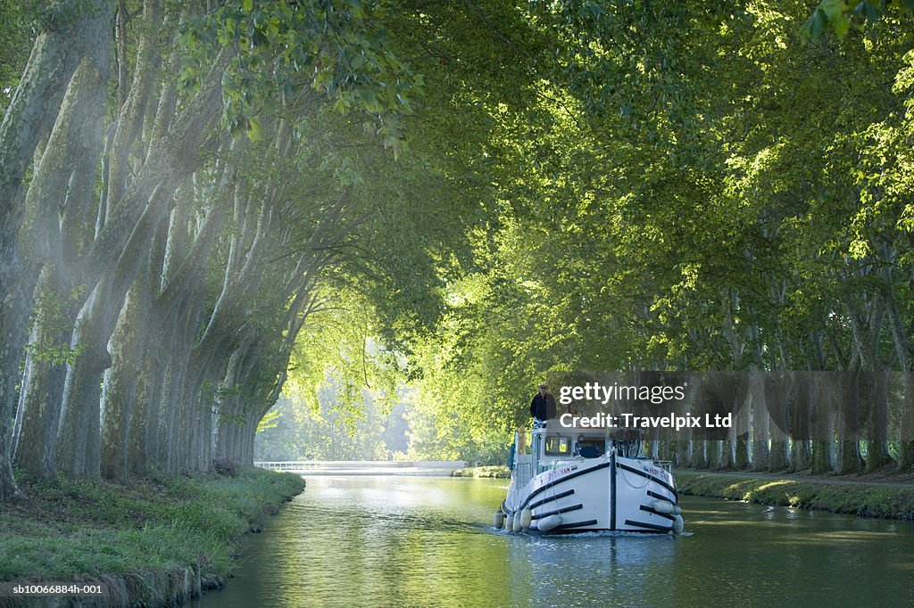 France, Languedoc, Carcassonne, boat in tree lined canal