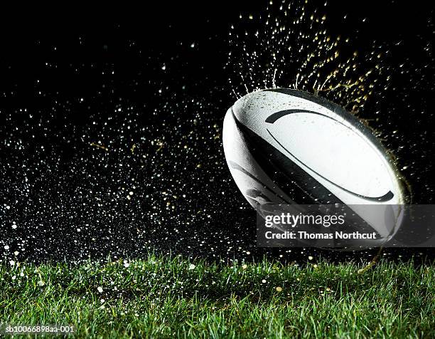 rugby ball in motion over grass - rugby stockfoto's en -beelden