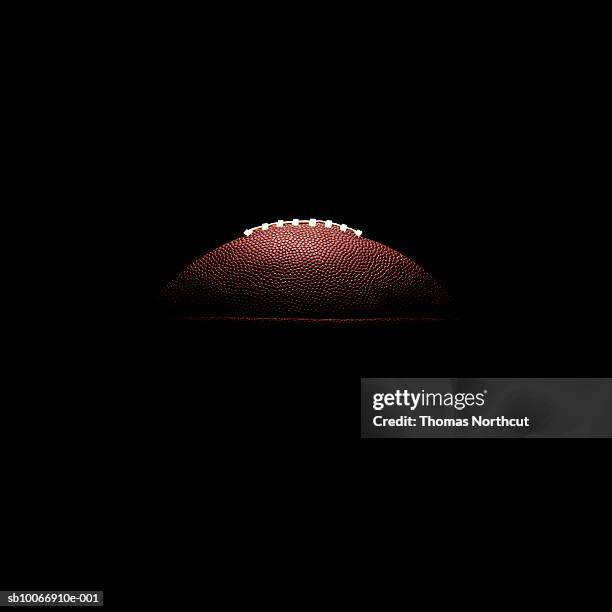american-football-ball, auf schwarzem hintergrund - amerikanischer football stock-fotos und bilder
