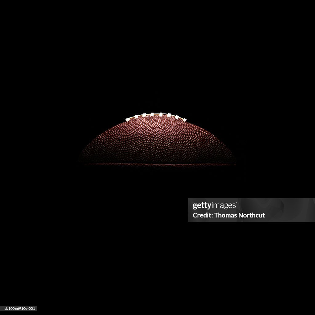 American football ball on black background