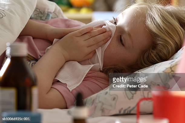 young girl (4-5 years) sick in bed with medicine - sick child stockfoto's en -beelden