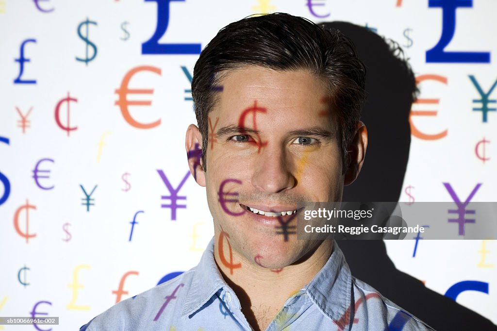 Visual projection of currency symbols cast on man, portrait, close-up