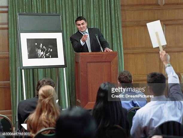 usa, texas, dallas, auctioneer taking bid on photograph at auction - auction stockfoto's en -beelden