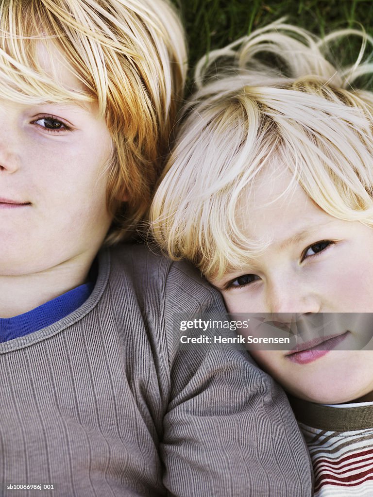 Two boys (8-11) lying on grass, portrait, elevated view