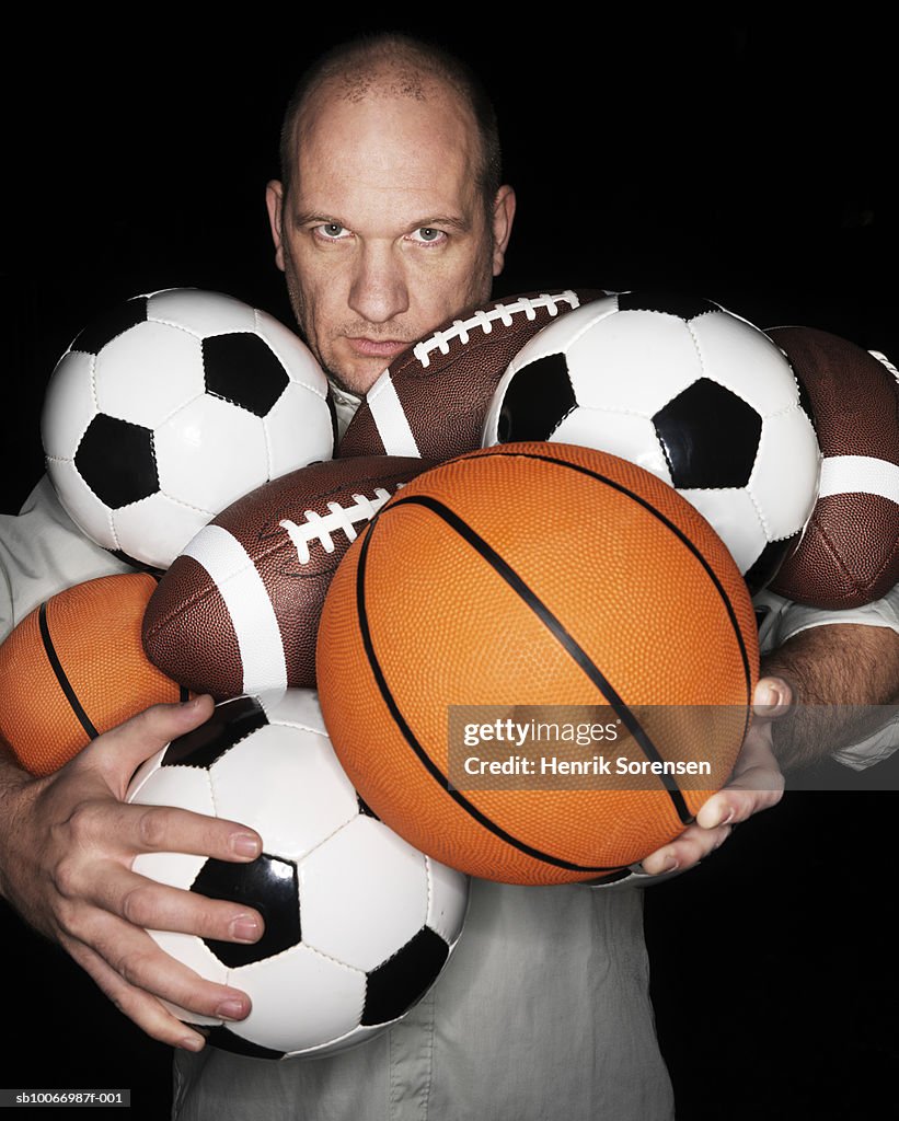 Man holding different balls, portrait