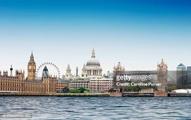london montage against plain blue sky with river thames in foreground - london england stock-fotos und bilder