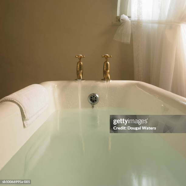 free standing bath with taps running - bathtub bildbanksfoton och bilder