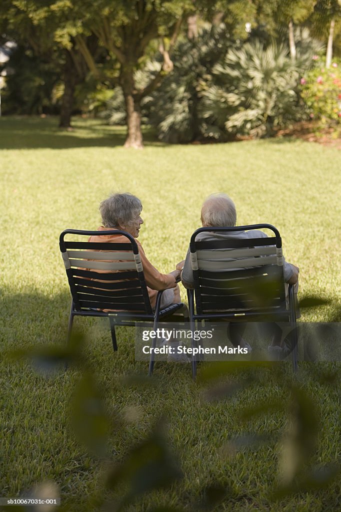 Senior couple sitting on chair, rear view