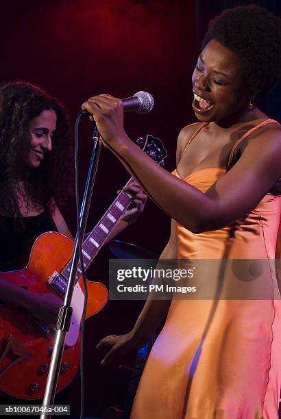 female singer and guitar player performing on stage - jazz music guitar stock pictures, royalty-free photos & images