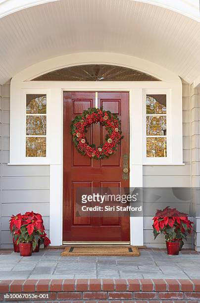 front door with wreath and poinsettias decoration - christmas decoration outdoor stock pictures, royalty-free photos & images