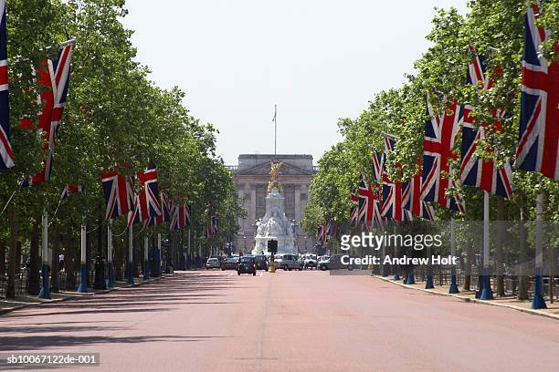 england, london, the mall with union jack flags towards buckhingham palace - buckingham palace stock-fotos und bilder