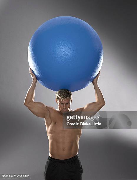 man holding exercise ball on head - mythologische gestalt stock-fotos und bilder